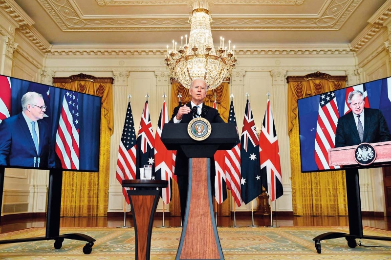 9月15日，美国总统拜登（中）在华盛顿白宫与英国首相约翰逊（右侧屏幕中）和澳大利亚总理莫里森（左侧屏幕中）举行视频会议