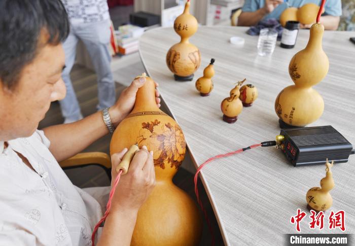 6月9日，丰润区非物质文化遗产传承人正在展示葫芦烙画技艺。　赵亮 摄