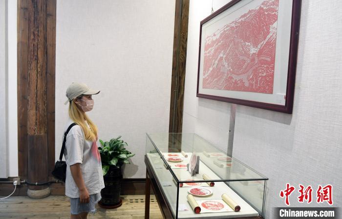 一名女青年观看福建德化民间剪刻纸艺术传承人的参展作品。　记者刘可耕 摄