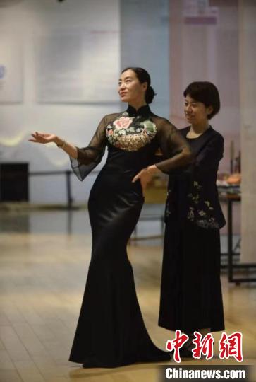 张丽娟(右)正在给旗袍爱好者试穿新创作的服饰作品。　陈璐 　摄