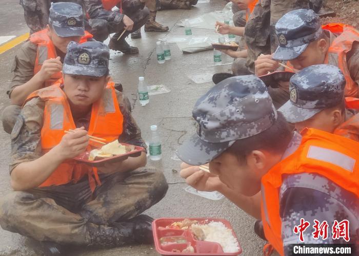 官兵連續奮戰近3小時，將堤壩防護好後，下午三點多才吃上午飯。　曾令欣 攝