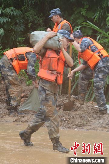 官兵冒雨蹚泥，運送沙袋。　曾令欣 攝