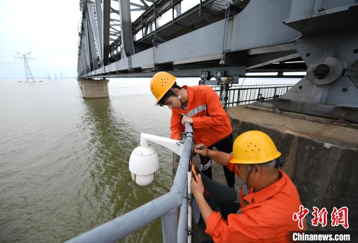 6月24日，南铁九江桥工段的桥梁工正在九景衢铁路鄱阳湖大桥上对监控摄像头进行检修。　胡国林 摄