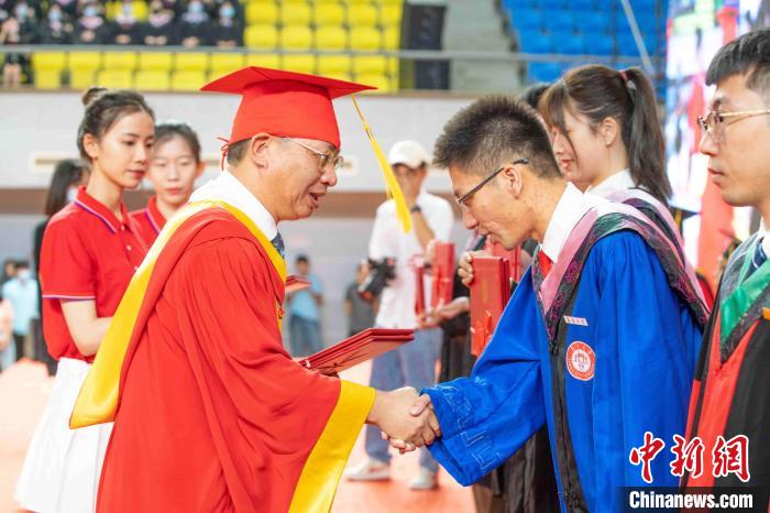 集大党委书记沈灿煌为毕业生代表颁发优秀毕业生证书。　刘金昆 摄