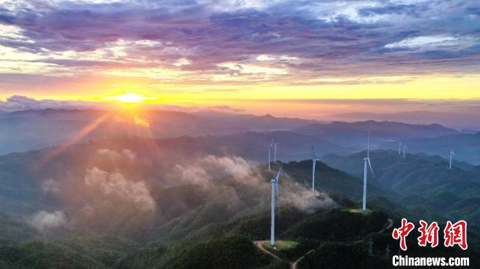 日出东方，将金色朝霞洒向高山之巅的风力发电场，风景壮美无比。　朱海鹏 摄