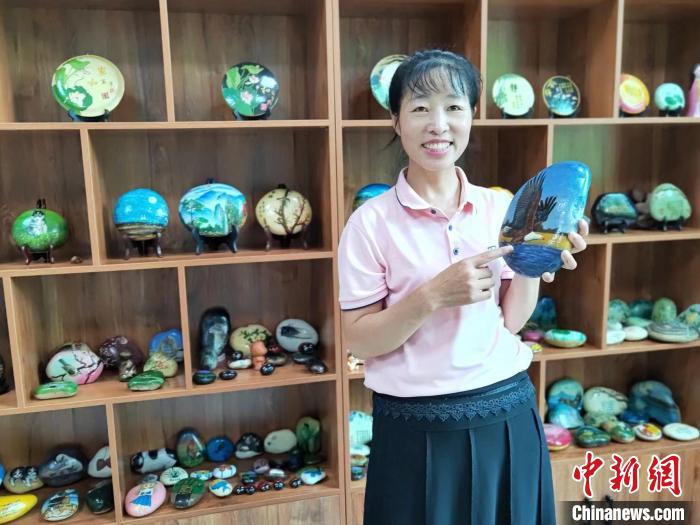 图为杜丽英介绍石画作品特征。　白云飞 摄
