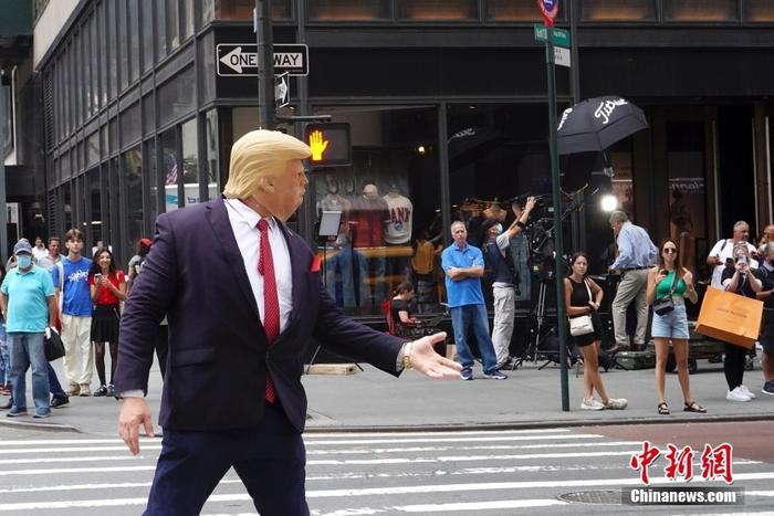 资料图：当地时间8月10日，一名戴着面具的示威者在美国纽约特朗普大厦外模仿美国前总统特朗普。近两日，特朗普大厦前示威者、记者、围观民众等人流聚集。 <a target='_blank' href='/'>中新社</a>记者 廖攀 摄