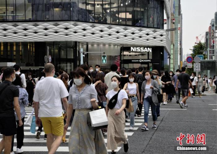 资料图：新冠疫情下，日本当地民众佩戴口罩走过东京街头。 <a target='_blank' href='/'>中新社</a>记者 吕少威 摄