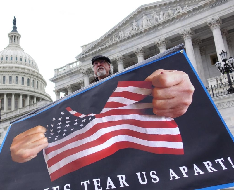 2020年2月3日，在美国华盛顿，抗议者在国会大厦前展示标语。新华社记者刘杰摄