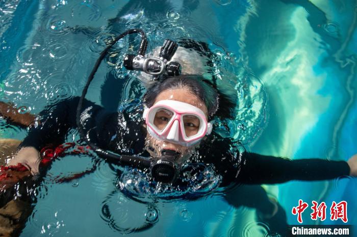 潜水员王媛媛从“岸上”一跃而下，潜入湛蓝的“海水”中。　高博 摄