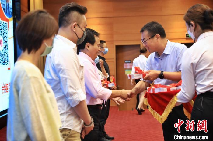 8月25日，北京市台办向台胞代表赠送《台胞百问》手册。　李雪峰 摄