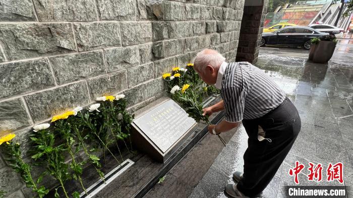 图为重庆大轰炸幸存者粟远奎向在重庆大轰炸中遇难的亲人和同胞敬献菊花。　肖江川 摄