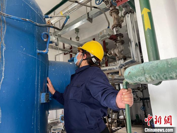 图为王卫玲认真检查锅炉设备。　朱永龙 摄