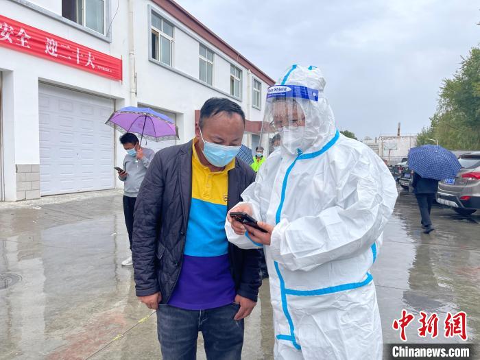 图为王卫玲(右)帮助做核酸的人员进行个人信息登记。　朱永龙 摄