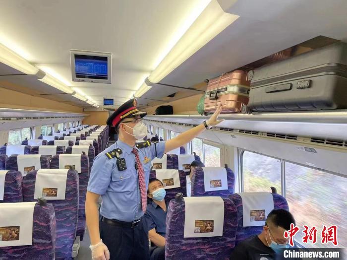 图为9月5日，D1797列车上，工作人员为旅客整理行李架。　张文杰 摄