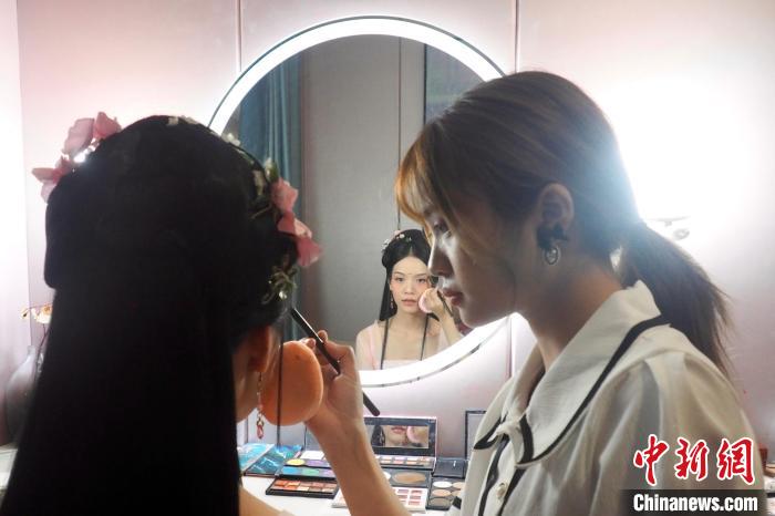 9月5日，广西柳州市城中区，汉服妆发设计师欧金洁在摄影馆的化妆间里为汉服模特化妆。　李娇阳 摄