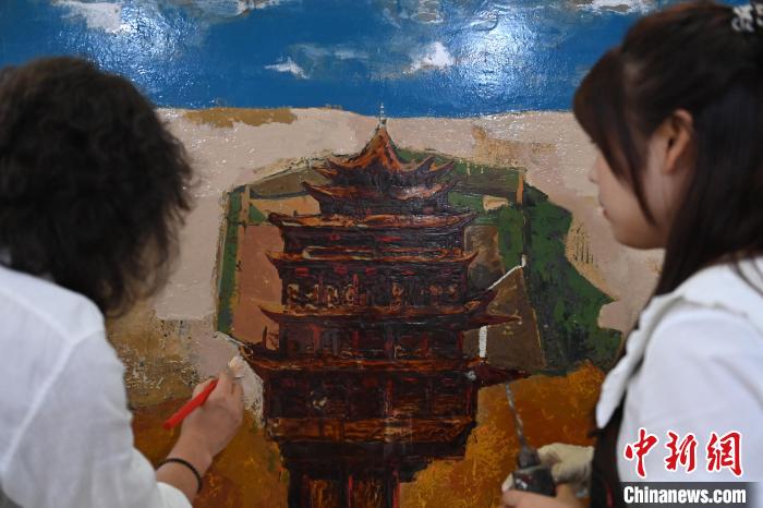 图为刘志刚与学生进行敦煌元素漆画创作。　李亚龙 摄