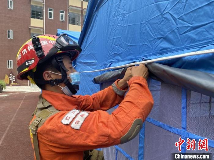 四川森林消防总队特勤大队刘志银正在帮助安置点搭建帐篷。　四川森林消防供图
