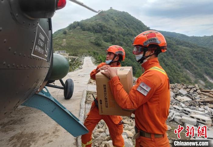 四川森林消防汶川大队卧龙中队消防员周亚东正在帮助卸载物资(右一)。　四川森林消防供图