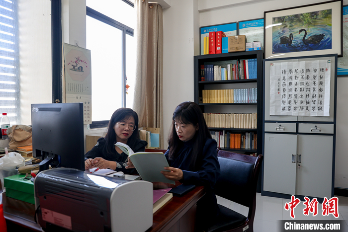 9月5日，周美华（左）和妹妹周敏华在办公室里备课交流。双胞胎姐妹周美华、周敏华来自台北，今年是她们在黄冈师范学院任教的第3年。“这里有我们热爱的文化，有愿意为之奉献的事业。”姐妹俩近日接受<a target='_blank' href='/'>中新社</a>记者专访时表示。她们是台湾中山大学中国文学系古典文献学专业博士，来黄冈前，曾在台湾东吴大学任教8年。2019年，黄冈师范学院赴台招贤纳士，姐妹俩经过慎重考虑，最终签约成为该校文学院特聘副教授。 <a target='_blank' href='/'>中新社</a>记者 张畅 摄