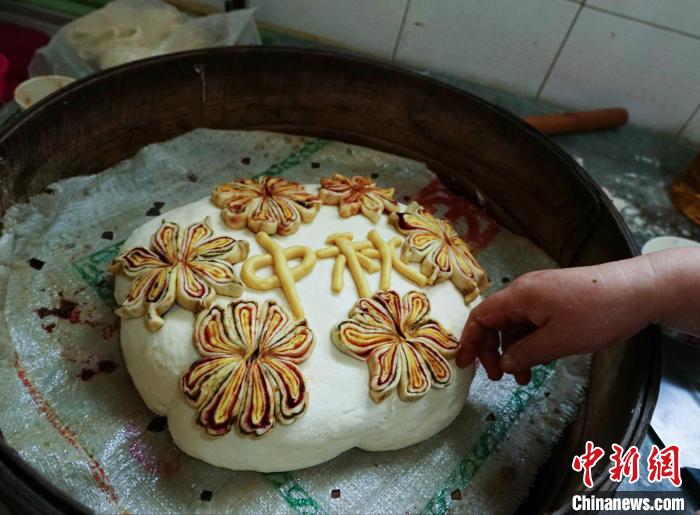 图为已用面花点缀好的青海传统蒸笼月饼。　马铭言 摄