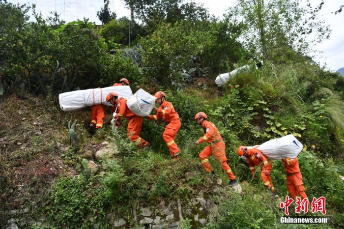 图为消防员徒步运送帐篷物资。 张浪 摄