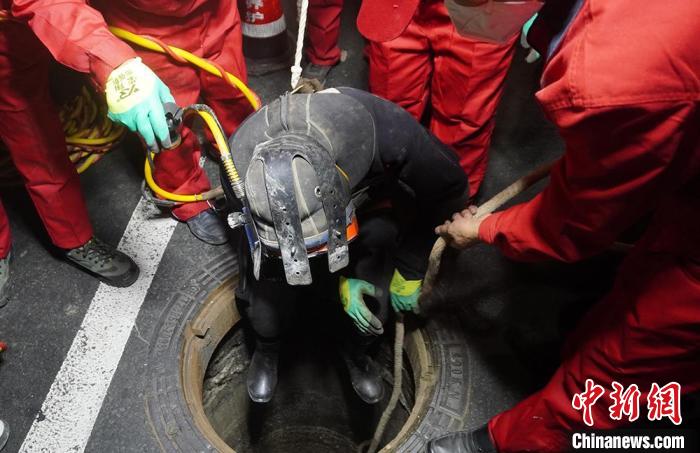 图为“市政蛙人”穿着厚重的潜水服，潜入污水管道内对堵塞管道进行疏通。　九美旦增 摄
