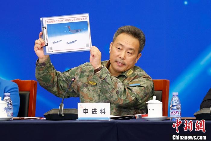 图为中国空军新闻发言人申进科大校在发布会上展示护送第九批在韩中国人民志愿军烈士遗骸归国时的“双20”编队图片。 <a target='_blank' href='/'>中新社</a>记者 富田 摄 　 　