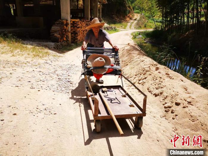 陈毅翔的父亲今年88岁，几乎每天推着手推车上山守护无名红军烈士墓。　雷朝良 摄