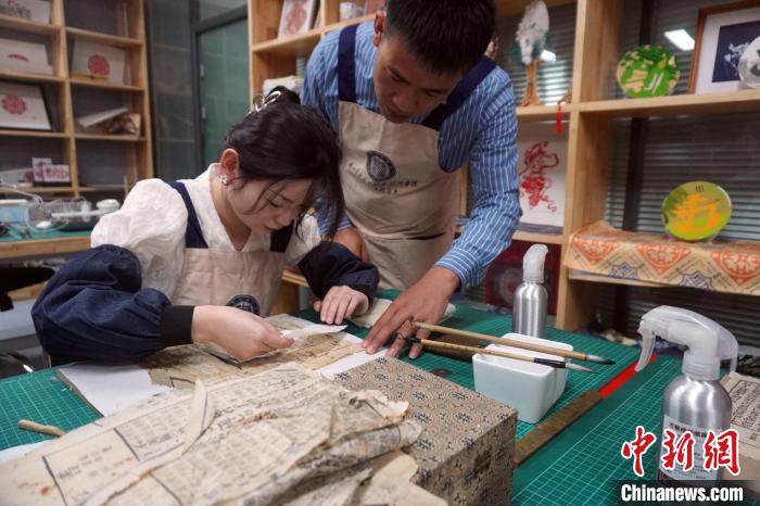 图为老师袁玉斌正在指导学生修复古籍。　九美旦增 摄