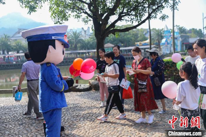 宣传玩偶正在给游客赠送宣传小礼品。　李袁辉 摄