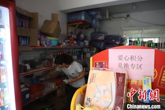 图为村民林玉珍在长门村的积分兑换超市内挑选自己所需的物品。　连江县融媒体中心供图