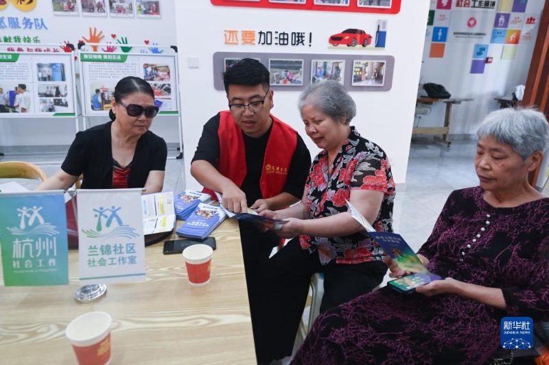 2022年9月6日，在浙江省杭州市临安区锦南街道兰锦社区党群服务中心，党员志愿者与社区的老年人进行沟通。新华社记者 徐昱 摄