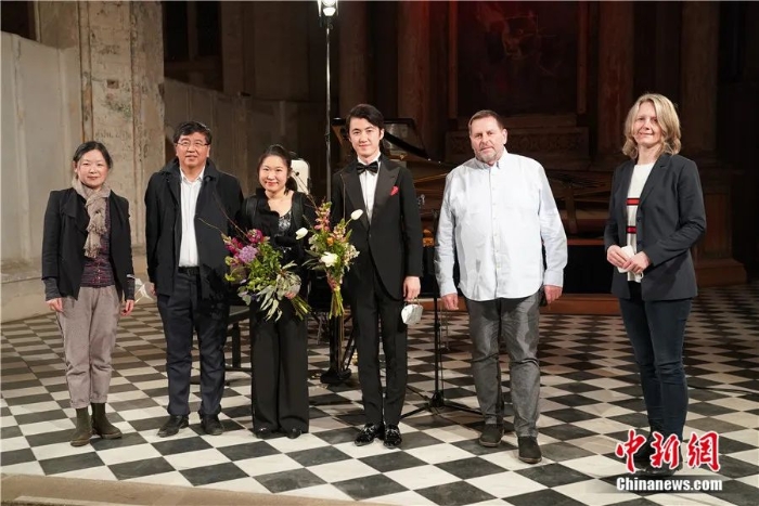 2022年3月18日，张海鸥(左四)和杨天娲(左三)与出席音乐会的嘉宾合影。当日，一场中国新春音乐会在德国汉萨古城施特拉尔松德上演。这也是德国范围内庆祝中德建交50周年的首批活动之一。彭大伟 摄


