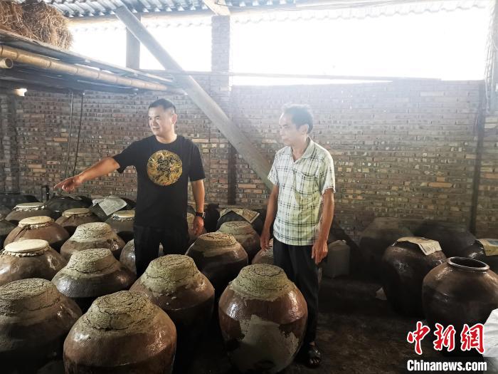 吴善远(左一)上门向农户收购黄酒。　屏南县委组织部 供图