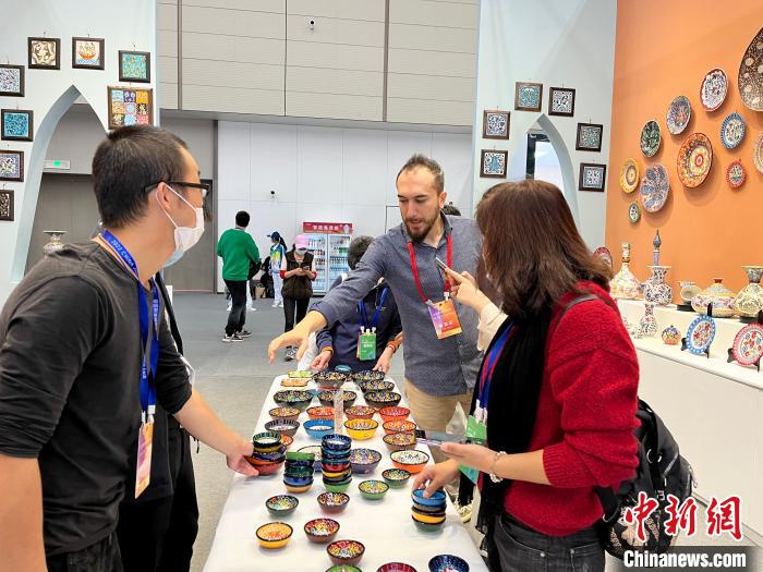 在土耳其陶瓷展位上，多名采购商正在询单。　李韵涵 摄