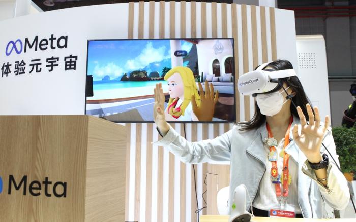 11月7日，在第五届进博会技术装备展区的人工智能专区，一名媒体工作人员借助VR头戴设备体验虚拟工作空间“元宇宙”交互应用。新华社记者 侯俊 摄