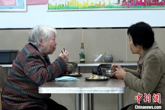 图为老人在餐厅内一边就餐一边闲聊。　高铖 摄