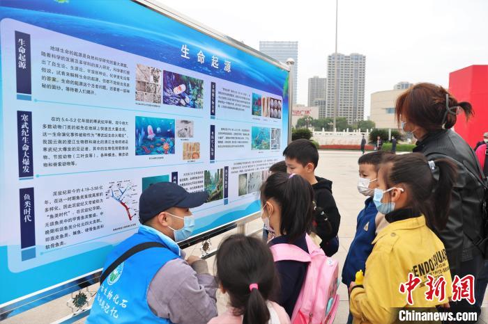 图为2022年度江西省古生物化石保护利用科普宣传活动南昌分会场，志愿者在给几位小朋友讲解科普知识。　刘力鑫 摄