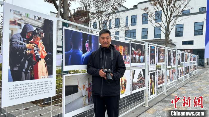 樊成柱与他的摄影作品合影 施亚磊 摄