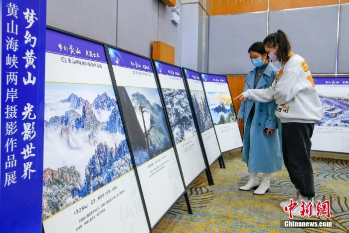 11月22日，游客在安徽黄山参观黄山海峡两岸摄影作品展。当日，“梦幻黄山 光影世界”黄山海峡两岸摄影作品展在安徽黄山和台湾新北同时开幕。据介绍，此次摄影展聚焦黄山的自然风光和人文景观，精选海峡两岸摄影家摄影作品40幅，分“水墨风雅”“雪凇仙域”“石破天惊”“云霞涌金”“人文揽胜”5个篇章。 <a target='_blank' href='/'>中新社</a>发 施亚磊 摄 　
