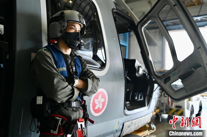 香港特区政府飞行服务队三级空勤主任吕嘉晴与猎豹直升机。　李志华 摄