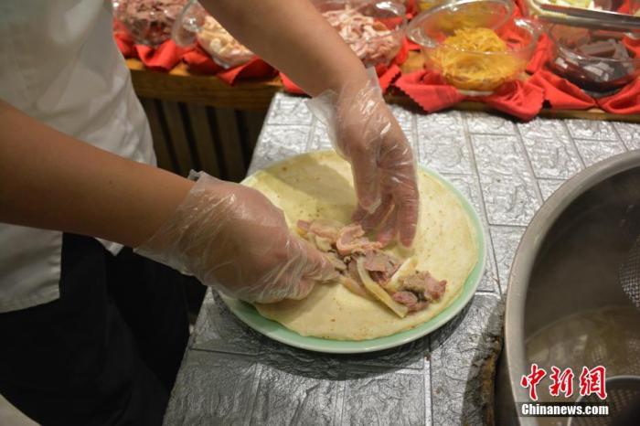 图为正在进行卷饼步骤的朝天锅。 <a target='_blank' href='/'>中新社</a>记者 吕妍 摄 　