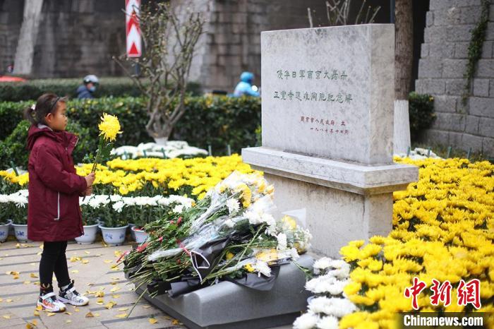 小学生向侵华日军南京大屠杀遇难同胞正觉寺丛葬地纪念献花。　泱波 摄