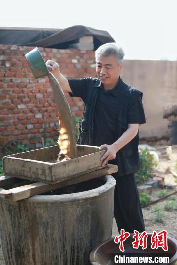 邢葆东在制作蛋壳陶杯用的泥料。　日照黑陶邢文化博物馆供图