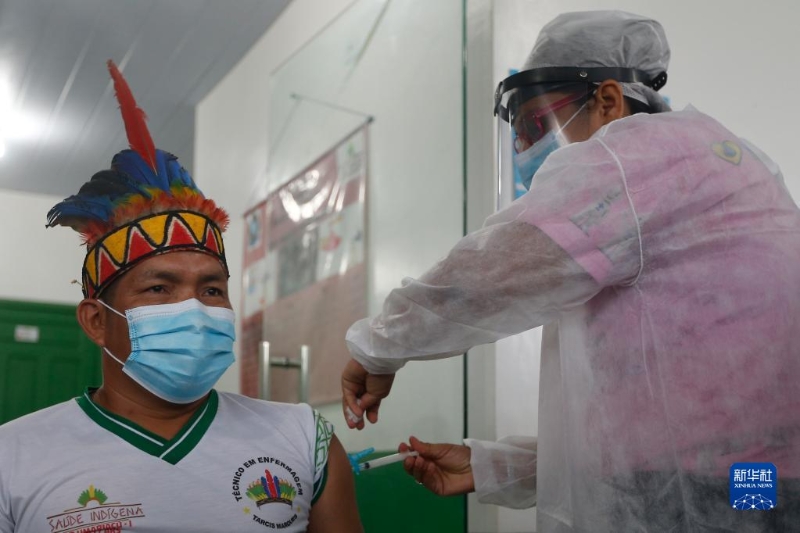 2021年1月19日，医护人员在巴西亚马孙州塔巴廷加市为一名原住民接种中国新冠疫苗。（新华社发 卢西奥•塔沃拉摄）