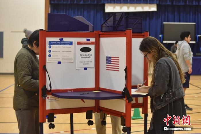 当地时间11月8日，美国中期选举举行，全美50个州以及华盛顿特区陆续开启投票站。图为位于弗吉尼亚州阿灵顿的一处投票站，民众正在填写选票。 <a target='_blank' href='/'>中新社</a>记者 沙晗汀 摄