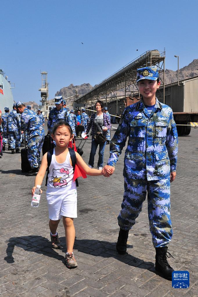 2015年3月29日，中国海军第十九批护航编队临沂舰抵达也门亚丁港，临沂舰女舰员帮助撤离的儿童登舰。新华社发（熊利兵摄）