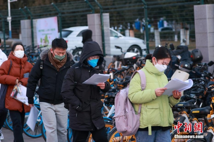 12月24日，2023年全国硕士研究生招生考试正式开考，全国报考人数为474万。图为北京工业大学考点外，考生在进入考场前加紧复习。 <a target='_blank' href='/'>中新社</a>记者 贾天勇 摄