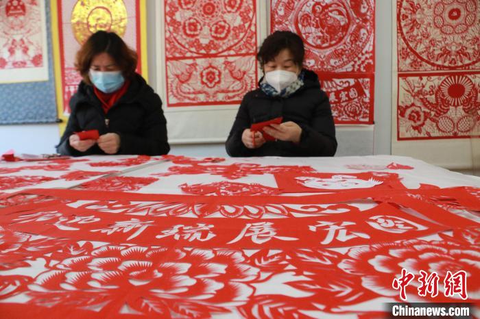 12月30日，在山东省高密市剪纸艺社，非遗传承人在进行迎新年剪纸创作。　李海涛 摄